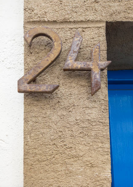 istock House number 24. Rusty iron over brown cement doorjamb 1358997160