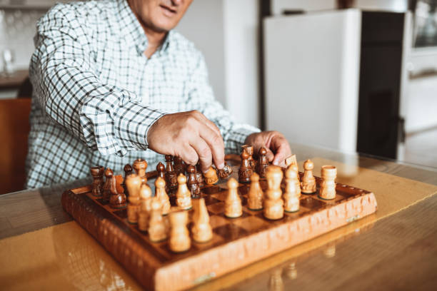 istock Senior Male Practicing New Chess Openings Alone At Home 1359000869