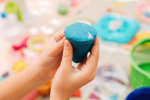 istock kinetic sand. children's hands play with multi-colored polymer sand. 1359001489