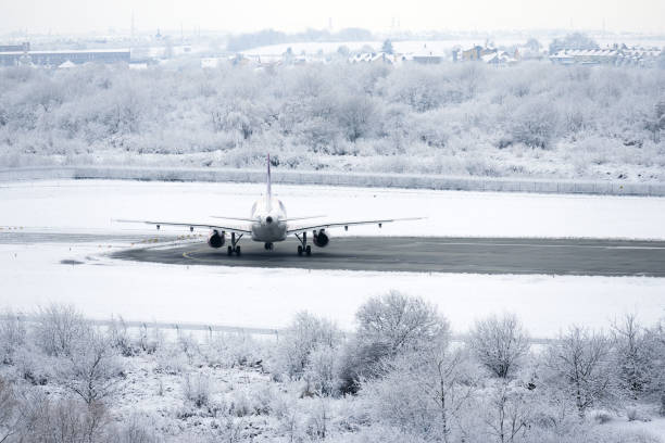 istock Airplane is getting ready for flight. Airliner on runway in blizzard. 1359004439