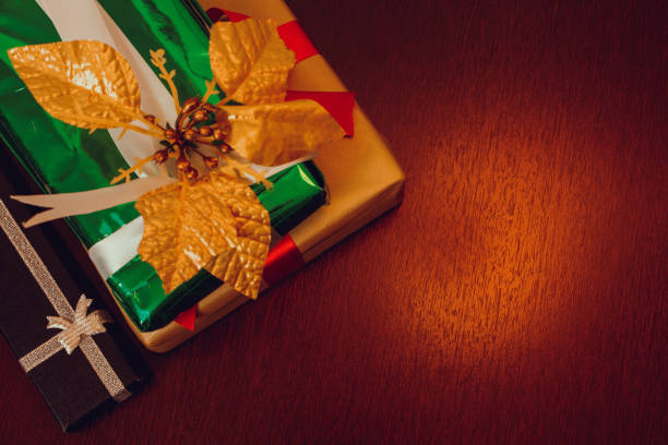 istock Christmas gift box. Christmas presents in red boxes at wooden table. Space for text. 1359007021