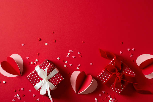 red background flat lay with gift, paper hearts, gift box, valentines day, mothers day concept - valentijn stockfoto's en -beelden