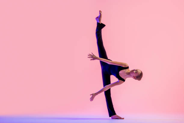 istock Young teenager dancer dancing on a red studio background. Ballet, dance, art, modernity, choreography concept 1359009619