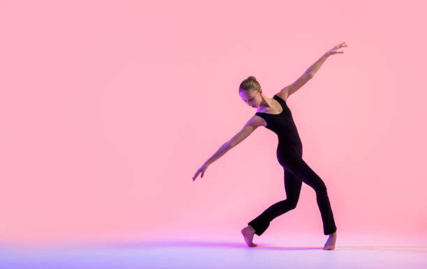 istock Young teenager dancer dancing on a red studio background. Ballet, dance, art, modernity, choreography concept 1359009631