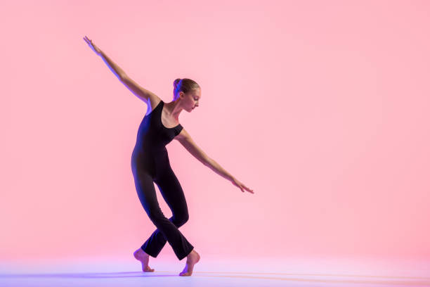 istock Young teenager dancer dancing on a red studio background. Ballet, dance, art, modernity, choreography concept 1359009660