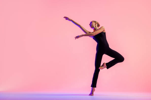 istock Young teenager dancer dancing on a red studio background. Ballet, dance, art, modernity, choreography concept 1359009745