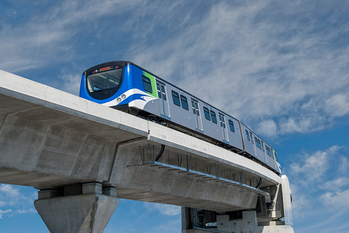 The Vancouver SkyTrain is a medium-capacity rapid transit system.  It serves the Metropolitan Vancouver, British Columbia, Canada area.  The SkyTrain has almost 50 miles of track and uses fully automated trains.  The track is grade-separated on underground and elevated guideways.  The trains cross the Fraser River on the worlds second-longest cable-supported transit bridge.  This photograph of the Sky Train was taken after it crossed the Fraser River in Richmond, British Columbia, Canada.