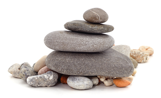 Balanced stones on a pebble beach during sunset