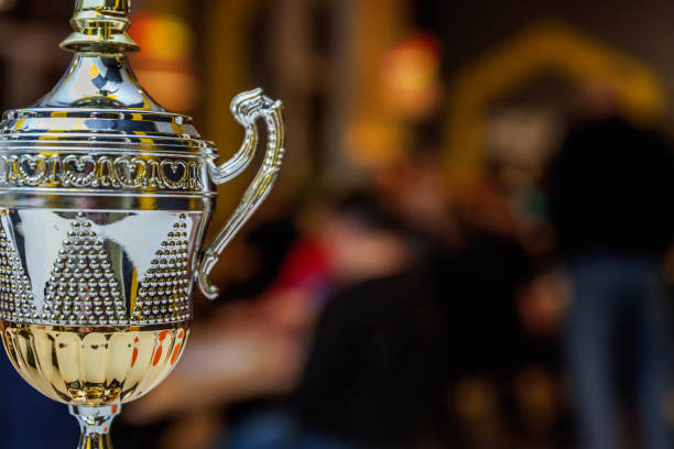 istock Winner or champion gold trophy cup with abstract dark blurred background. Victory first place of competition. Winning or success concept 1359019370