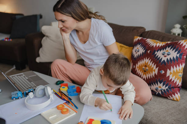 istock Young mother works on laptop at home 1359025738