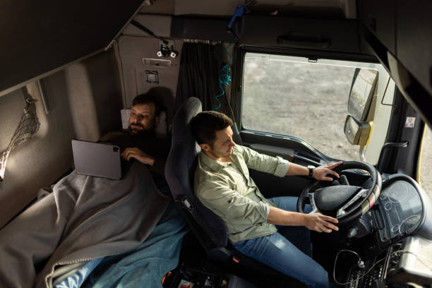 istock Truck driver driving while his colleague resting on bed in passenger cabin 1359026012
