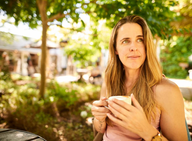 istock Thoughtful woman having coffee outdoors 1359026061