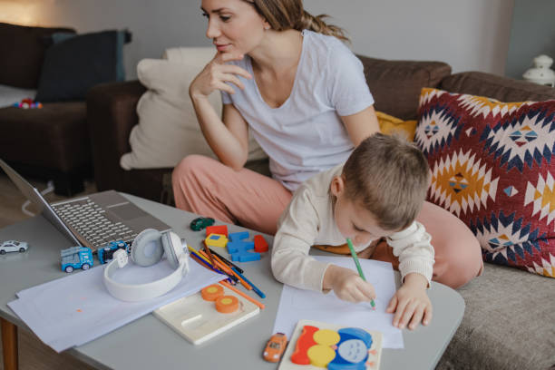 istock Young mother works on laptop at home 1359026091