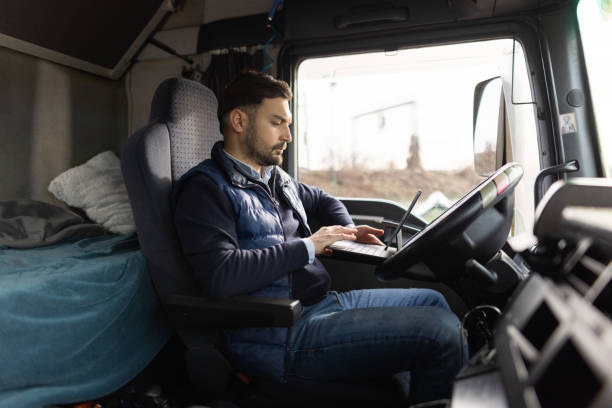istock Truck driver typing destination on tablet while sitting in cabin 1359026743