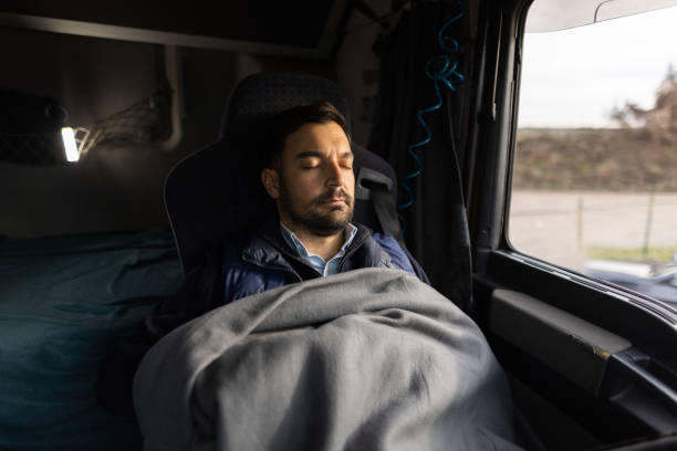 istock Truck driver taking break during driving and napping on driver's seat 1359026988