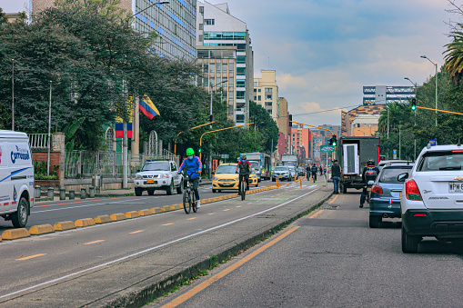 Bogotá, Colombia - November 13,, 2021: The drivers point of view on the Northbound carriageway of Carrera Septima driving through the Chapinero area in the Andean capital city of Bogota, in South America. To the left are the Southbound carriageways. There are office and residential apartment buildings on both sides of the major arterial road. The Bicycle Lane can be seen to the left and the clearly marked Bus Lane to the extreme left; it leaves only one other lane for all other traffic to compete on, and makes driving in the area difficult and an irritable experience. The altitude at street level is 8,660 feet above mean sea level. Horizontal format. Copy space.