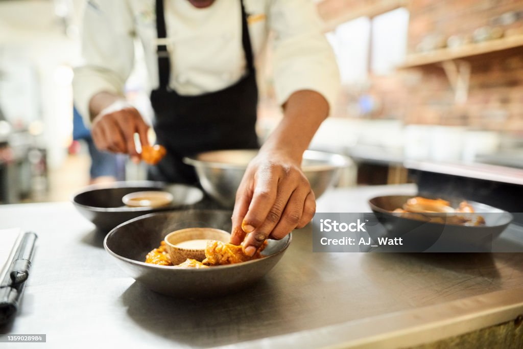 Restaurant chef preparing a dish Close-up of male chef arranging food on a dish in the commercial kitchen Chef Stock Photo