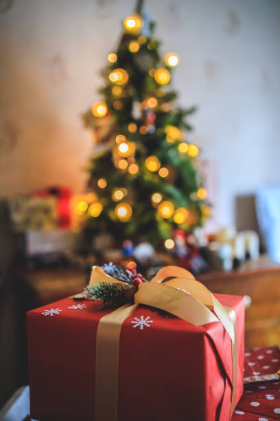 istock beautiful gift on a bokeh background with a Christmas tree. Copy space 1359030749