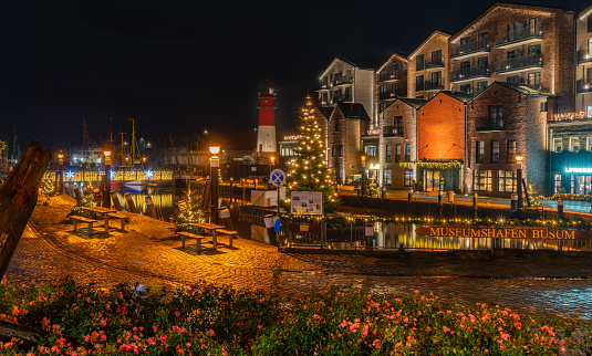 View of of festive lighting and Christmas romantic atmosphere in the Büsum at night. Nighttime view of Büsum at Christmas time. Maritime Christmas city. Signboard 