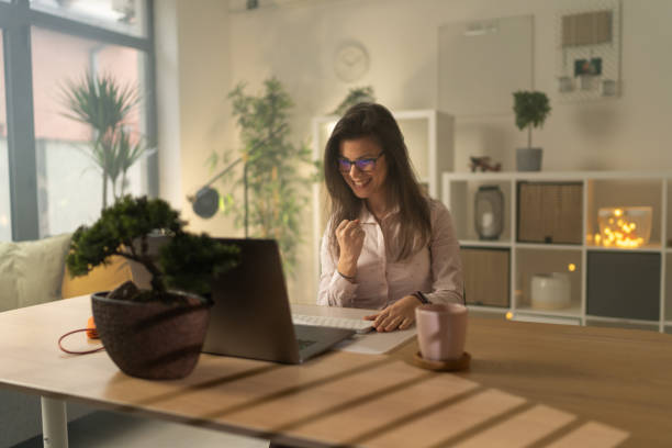 istock Smiling woman cheering while sitting in office and working 1359033977