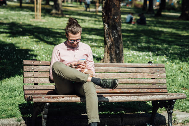 istock Young man in the park taking a break and using smartphone 1359036338
