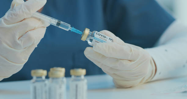 istock Shot of an unrecognizable doctor using a syringe to extract medication from a via 1359037008