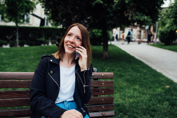 istock Beautiful girl sitting on the bench and telephoning 1359037101