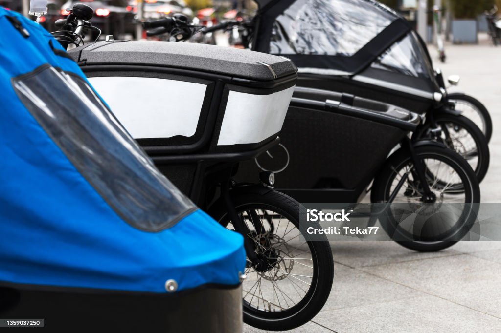 modern cargo bikes in a row in a city Cargo Bike Stock Photo