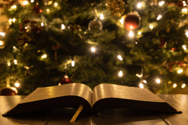 istock Open bible close up in front of Christmas tree 1359038001