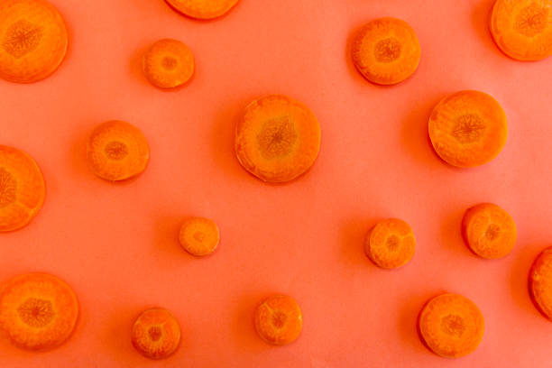 istock Carrot slices on orange background top view. 1359038074