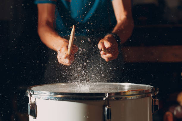 istock Drum sticks drumming beat rhythm on drum surface with splash water drops 1359043499