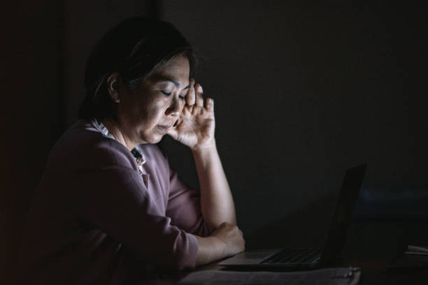Businesswoman having a headache while using laptop stock photo