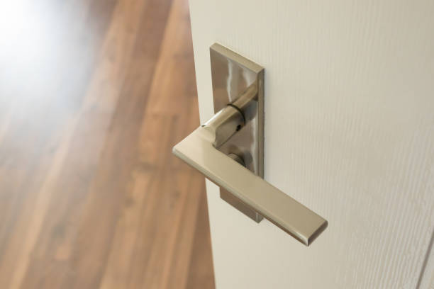istock Modern door handle on white door with room interior 1359043912