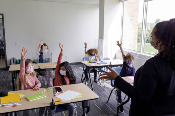 istock Multi-ethnic group of children wearing protective face masks at school 1359046728
