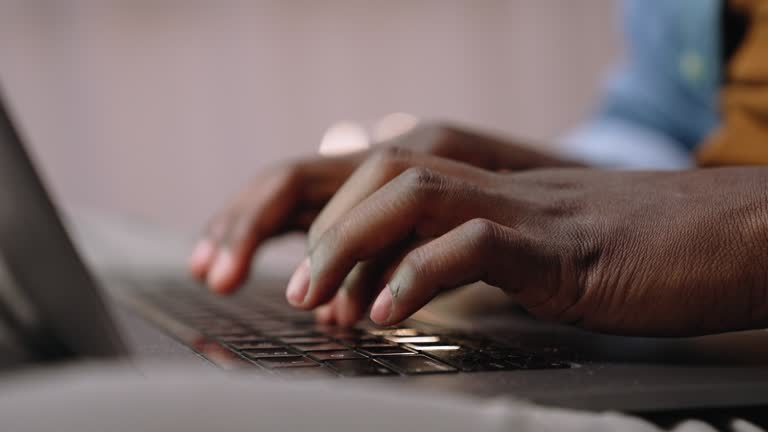 Close up of male hands typing on laptop keyboard