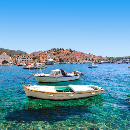 Square image of the colorful boats floating in the crystal clear water of Hvar harbor Croatia