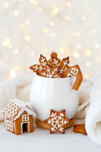 istock Christmas composition with white mug with hot chocolate and gingerbread coockies. Holiday atmopshere, cozy handmade decor. Lights on background, bokeh. Close up 1359052137