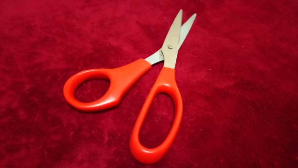 istock Stainless steel scissors and orange anatomic handle, for cutting and sewing work as well as school work 1359056550