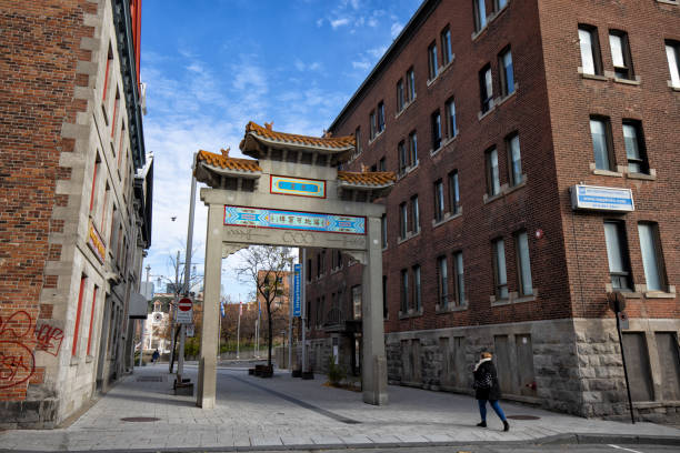 Montreal, Canada - November 20, 2021: Woman walking by the Chinese gate at Chinatown in the downtown district.