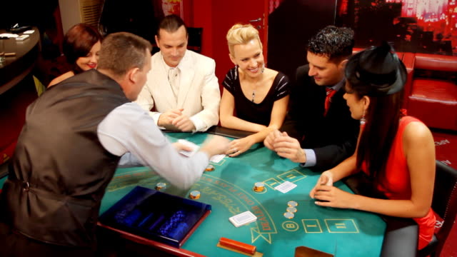 Croupier passing cards to blackjack gamblers in casino.