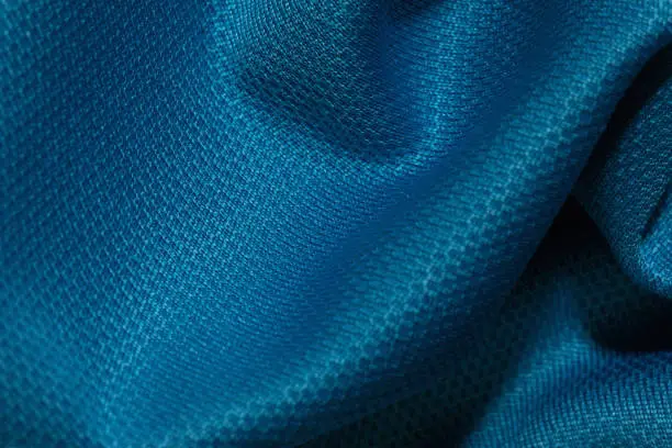 Blue crumpled fabric background. Abstract texture, empty template. Selective focus.