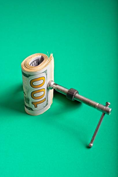 istock Clamp squeezing roll of U.S. 100 dollar bills 1359066407