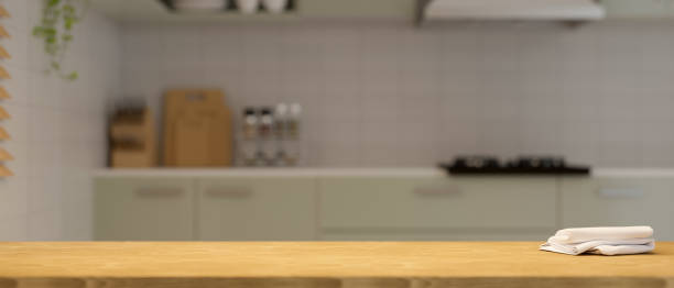 istock Empty wooden tabletop over modern apartment kitchen in the background. 1359069907