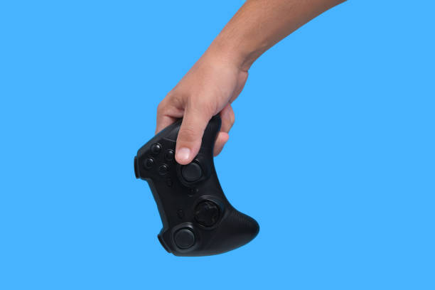 istock Gamepad in man hand on blue background, game joystick, computer games and entertainment. 1359071100