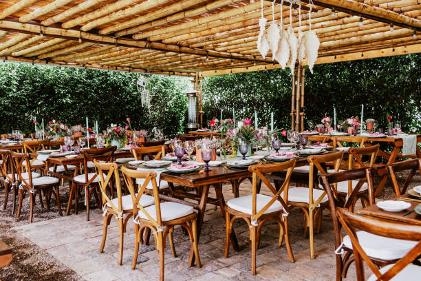 terrace with tables setup with flowers and plates on table decorated for Wedding Reception in Latin America terrace with tables setup with flowers and plates on table decorated for Wedding Reception in Latin America wedding feast stock pictures, royalty-free photos & images
