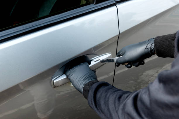 istock Car thief man with a tool trying to break door car 1359081741