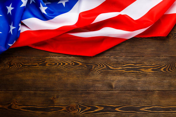 istock crumpled usa flag on flat textured wooden surface background 1359084993