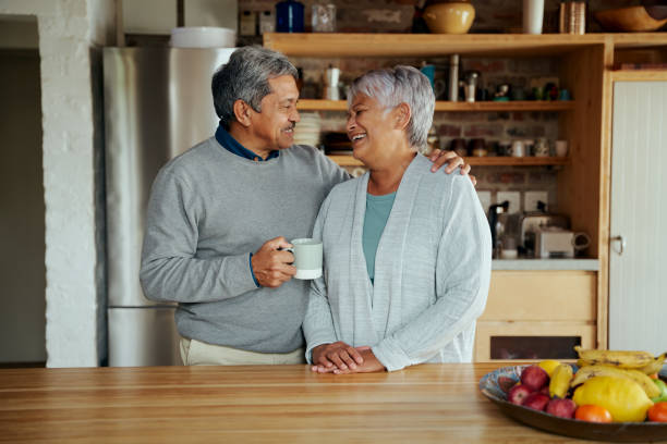 istock Loving retired elderly biracial couple laughing at each other while standing in modern kitchen 1359089498