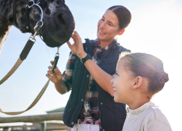 목장에서 밖에서 말을 애무하는 매력적인 젊은 여성과 그녀의 딸의 자른 샷 - teaching child horseback riding horse 뉴스 사진 이미지