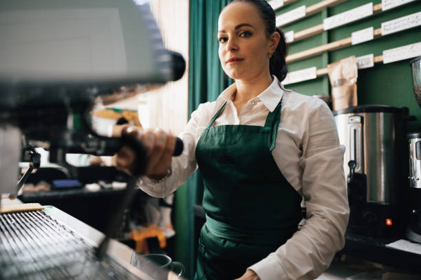 istock Caucasian female barista at work making coffee 1359093655